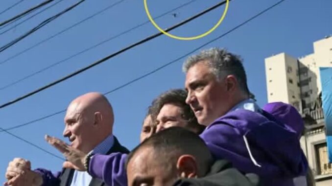 Presidente argentino Javier Milei em carreata, com segurança próxima, enquanto um objeto é arremessado do alto em sua direção.