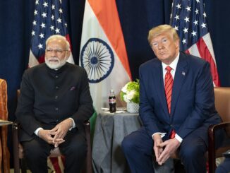 Primeiro-ministro Narendra Modi e presidente Donald Trump sentados lado a lado em reunião bilateral na sede da ONU, com bandeiras da Índia e dos EUA ao fundo.
