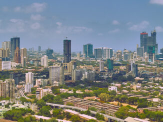 Linha do horizonte panorâmica de Mumbai com arranha-céus e áreas verdes, destacando o crescimento econômico da cidade.