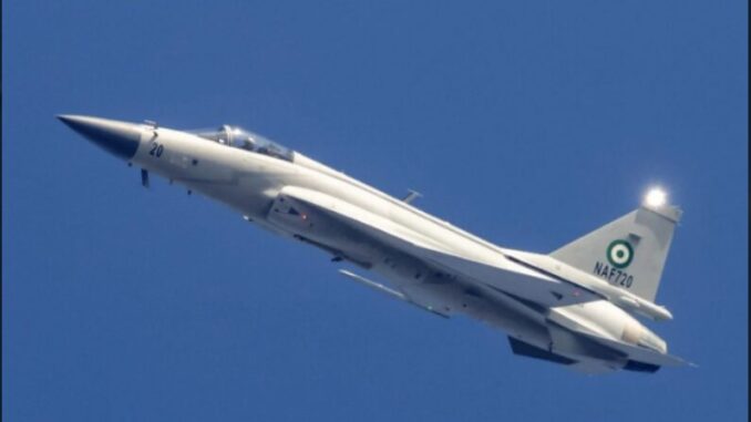 Caça JF-17 da Força Aérea da Nigéria em voo Caça JF-17 branco da Força Aérea da Nigéria voando contra céu azul claro