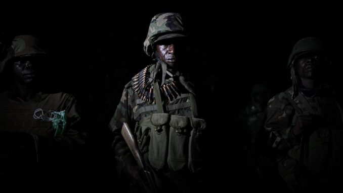 Soldados ugandeses da Missão da União Africana na Somália (AMISOM) em operações noturnas, armados e em formação, durante ofensiva conjunta com o Exército Nacional Somali.