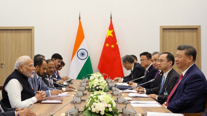 Narendra Modi e Xi Jinping durante reunião bilateral no 16º BRICS Summit, com delegações da Índia e China sentadas frente a frente.