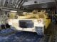 Tanque militar M1 Abrams sendo transportado dentro de um avião de carga com militares ao fundo.