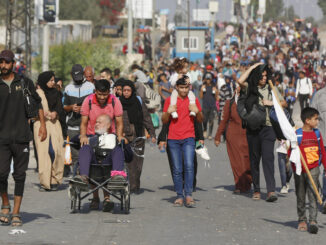 Palestinos fugindo de suas casas em Gaza em novembro de 2023, incluindo crianças, idosos e pessoas com mobilidade reduzida, carregando pertences pessoais.