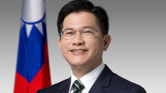 Lin Chia-lung, Ministro das Relações Exteriores de Taiwan Retrato oficial de Lin Chia-lung, Ministro das Relações Exteriores de Taiwan, vestindo terno escuro e gravata, com a bandeira de Taiwan ao fundo.
