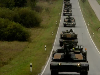 Tanques e veículos militares em comboio deslocando-se por estrada europeia