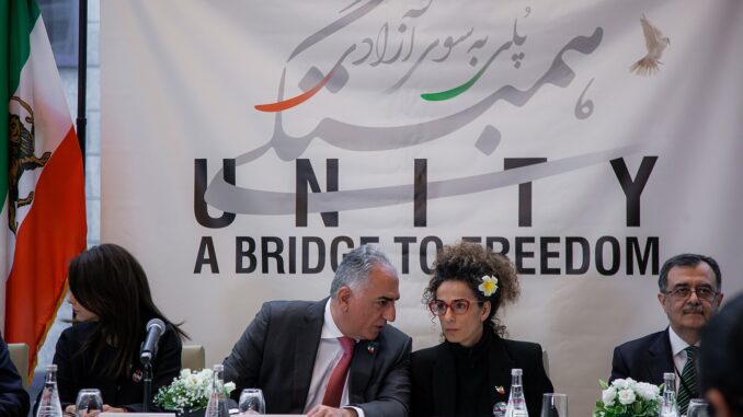 Fotografia de Mahsa Amini, Reza Pahlavi e Masih Alinejad em evento de solidariedade, simbolizando apoio à democracia e aos direitos humanos no Irã.