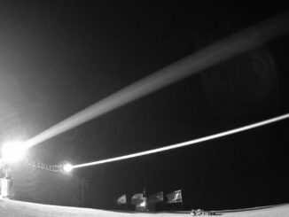 Foto do sistema de defesa a laser Iron Beam da Rafael, em operação noturna, disparando feixes de energia contra alvos simulados.