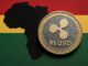 Moeda digital RLUSD da Ripple sobre mapa da África com cores de bandeira, simbolizando inclusão financeira e remessas internacionais no continente.