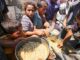 Crianças e famílias palestinas em Deir el-Balah recebem alimentos distribuídos por organizações humanitárias na Faixa de Gaza.