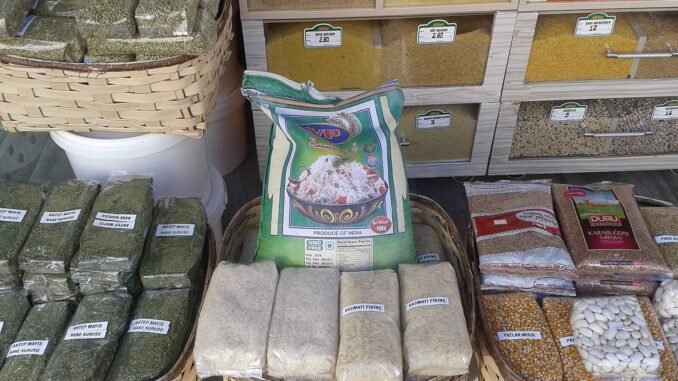 Contêineres e sacos de arroz sendo preparados para exportação na Índia, ilustrando o comércio internacional do país.