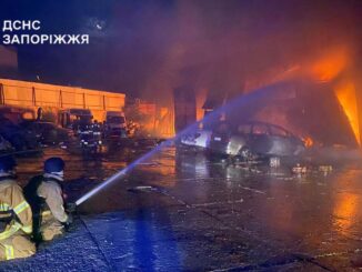 Equipes de resgate combatem incêndio em veículos e prédios após ataque russo com foguetes em Zaporizhia, Ucrânia.