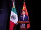 Representante da China discursando em frente às bandeiras do México e da China em evento oficial.