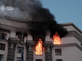 Prédio do governo de Kiev em chamas durante ataque aéreo russo, com fumaça negra saindo das janelas.