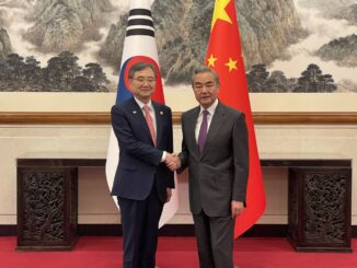O ministro das Relações Exteriores da Coreia do Sul, Cho Hyun, cumprimenta o ministro chinês Wang Yi em Pequim, com as bandeiras da Coreia do Sul e da China ao fundo.