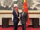 O ministro das Relações Exteriores da Coreia do Sul, Cho Hyun, cumprimenta o ministro chinês Wang Yi em Pequim, com as bandeiras da Coreia do Sul e da China ao fundo.