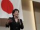 Sanae Takaichi discursando durante palestra na província de Fukuoka, Japão, em 25 de agosto de 2025, com público presente e representantes do LDP.