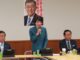 Sanae Takaichi falando em reunião do Grupo de Estudos de Segurança Pública, Terrorismo e Combate ao Crime Cibernético do PLD, com membros do partido e laptops à mesa.