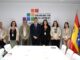 Pedro Sánchez posa com delegados em conferência internacional de financiamento para desenvolvimento, com bandeiras da Espanha e da União Europeia ao fundo.