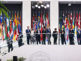 Reunião internacional no prédio do FMI em 25 de junho de 2025, com delegações e bandeiras de diversos países.