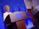 Ursula von der Leyen em coletiva de imprensa ao lado de autoridades europeias, com bandeiras da União Europeia ao fundo.