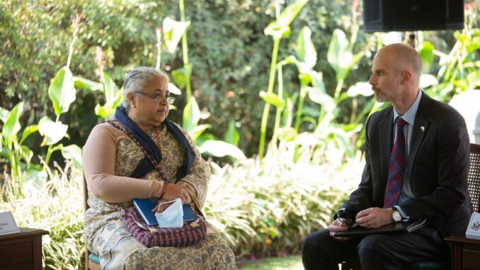 Sushila Karki, ex-presidente do Supremo Tribunal do Nepal e primeira-ministra interina, em reunião ao ar livre com um representante diplomático.