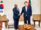 Presidente de Moçambique, Filipe Nyusi, cumprimenta o Presidente da Coreia do Sul, Yoon Suk Yeol, durante encontro oficial em Seul, com bandeiras nacionais ao fundo.
