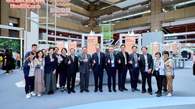 Participantes da feira de inovação e tecnologia em Taiwan posando em estande de exposição, mostrando a colaboração internacional no setor de defesa e tecnologia.
