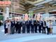 Participantes da feira de inovação e tecnologia em Taiwan posando em estande de exposição, mostrando a colaboração internacional no setor de defesa e tecnologia.